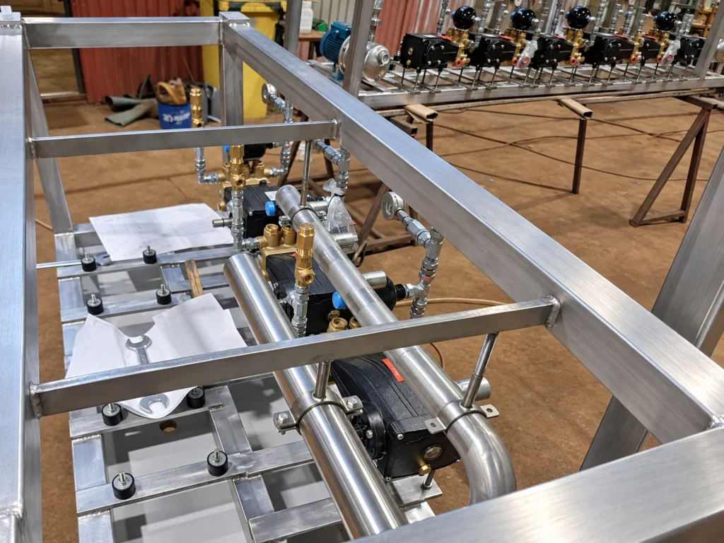 Widok z góry na nierdzewny zespół technologiczny z pompami i armaturą